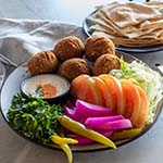 Falafel Plate with lettuce, tomato, pickles, herbs & bread